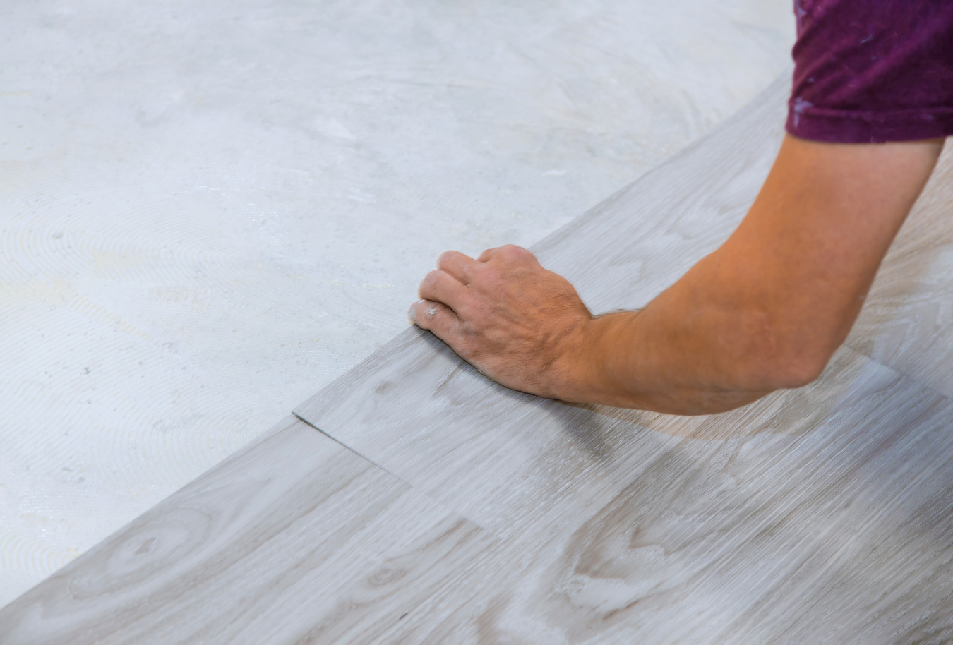Worker Installing New Vinyl Tile Laminate Floor